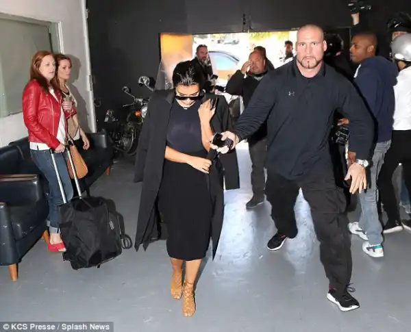 Kim K looks shaken as she arrives @ Paris studio flanked by burly security